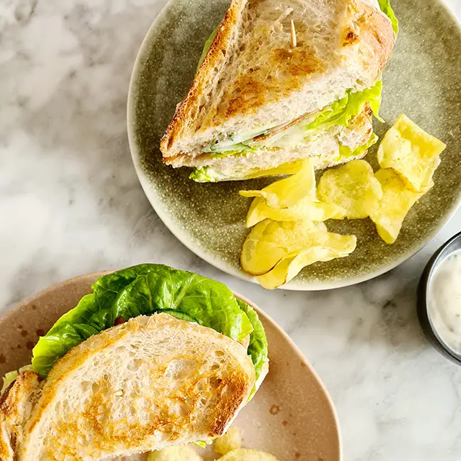 Clubsandwich met bacon eten